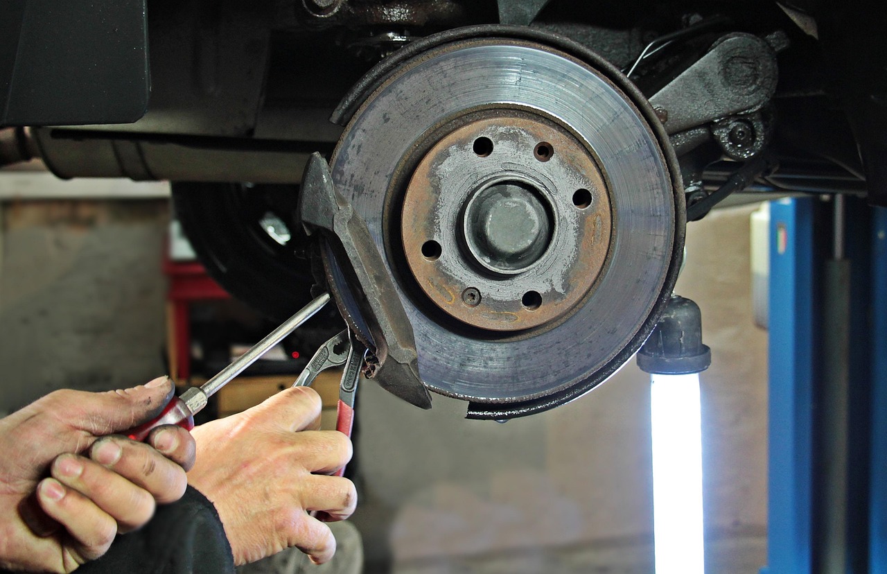 auto mechanic working on car brakes
