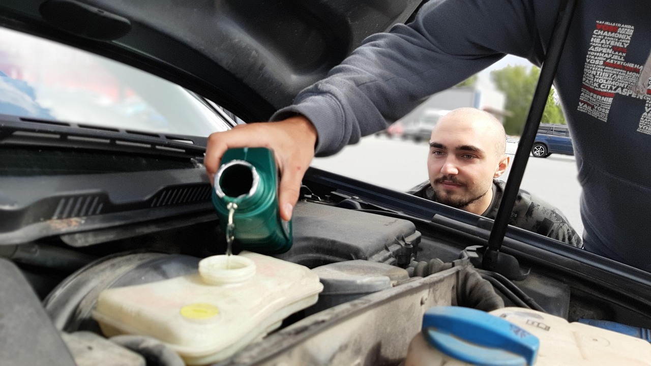 auto mechanic changing car oil