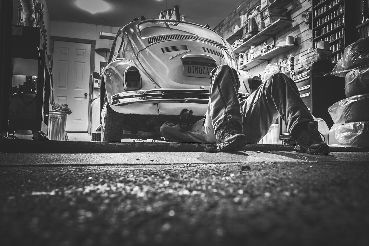 auto mechanic servicing car air conditioning